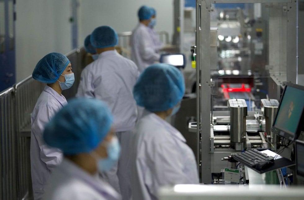 El presidente de la farmacéutica estatal china Sinopharm, Liu Jingzhen, anunció este viernes que la compañía prevé producir este año 1.000 millones de dosis de su vacuna inactivada contra el coronavirus, una buena parte de ellas destinadas a la exportación. Imagen de trabajadores en el taller de envasado en Beijing. (Texto: EFE / Foto: AFP)