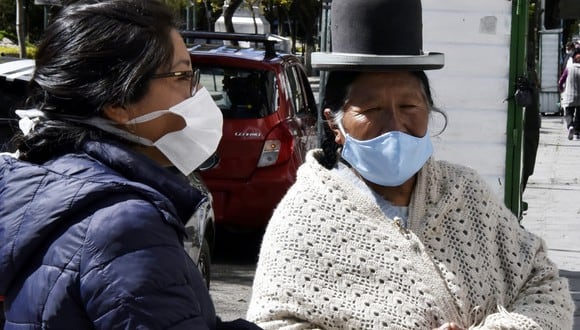 Las mujeres usan máscaras faciales en un mercado callejero en La Paz, durante un cierre total ordenado por el gobierno hasta el 15 de abril contra la propagación del nuevo coronavirus. (Foto: AFP/Aizar Raldes)