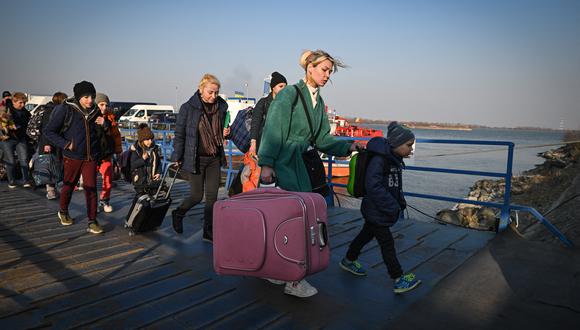 Refugiados de Ucrania caminan por el embarcadero después de llegar en ferry al punto fronterizo rumano-ucraniano Isaccea-Orlivka. (Foto: Daniel MIHAILESCU / AFP)