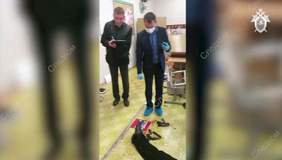 Los investigadores trabajan junto al cuerpo de un pistolero en la escuela No88 en Izhevsk, Rusia. (AFP).