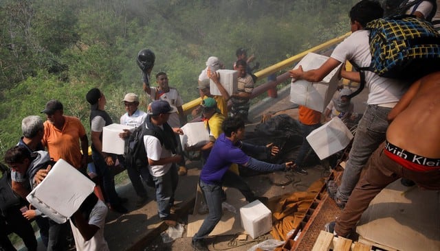 Los venezolanos desesperados tratan de rescatar lo que queda de la ayuda humanitaria quemada por el régimen de Nicolás Maduro. (Fotos: Agencias)