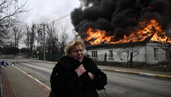Una mujer reacciona frente a una casa en llamas después de ser bombardeada en la ciudad de Irpin, en las afueras de Kyiv, el 4 de marzo de 2022. (Foto de Aris Messinis / AFP)