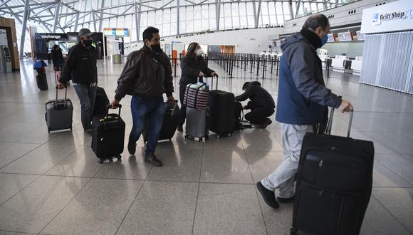 Pasajeros varados caminan con su equipaje en la sala de facturación del Aeropuerto Internacional de Carrasco en Ciudad de la Costa, Departamento de Canelones, cerca de la capital uruguaya Montevideo. (Foto: Eitan ABRAMOVICH / AFP)