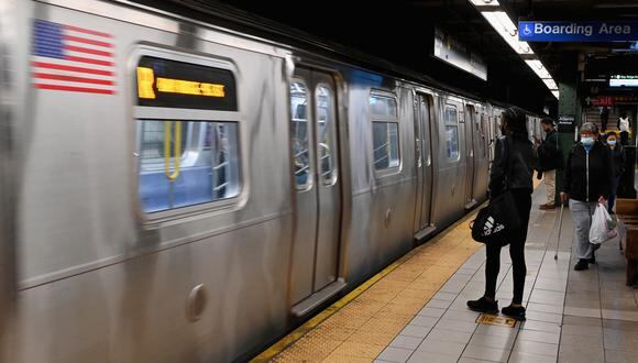 Las personas viajan a través de una estación de metro en la ciudad de Nueva York el 13 de abril de 2022, un día después de que las personas resultaron heridas durante un tiroteo en la hora pico en el distrito de Brooklyn de Nueva York. (Foto de Ángela Weiss / AFP)