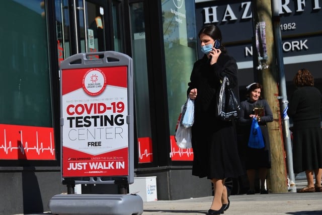 Una persona pasa por delante de un centro de pruebas de coronavirus en la sección Borough Park de Brooklyn, uno de los cinco distritos de la ciudad de Nueva York (Estados Unidos). (AFP/Angela Weiss).