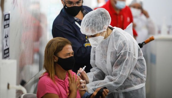 Una mujer reacciona luego de recibir una dosis de la vacuna CoronaVac contra Covid-19 en un puesto de vacunación en Brasilia, Brasil. (Foto: Sergio Lima / AFP)