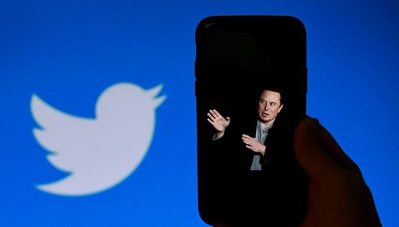 La pantalla de un teléfono muestra una foto de Elon Musk con el logotipo de Twitter de fondo en Washington, DC. (Foto de OLIVIER DOULIERY / AFP)