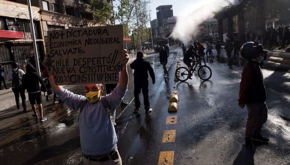 Un manifestantes sostiene un cartel durante una protesta en la Plaza Italia de Santiago. (EFE/Alberto Valdés).
