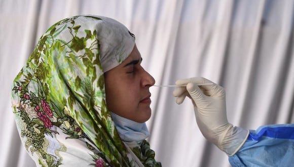 Un trabajador de la salud realiza un test de coronavirus a una mujer en un centro de pruebas en Srinagar, el pasado 12 de abril de 2021. (Foto de TAUSEEF MUSTAFA / AFP).