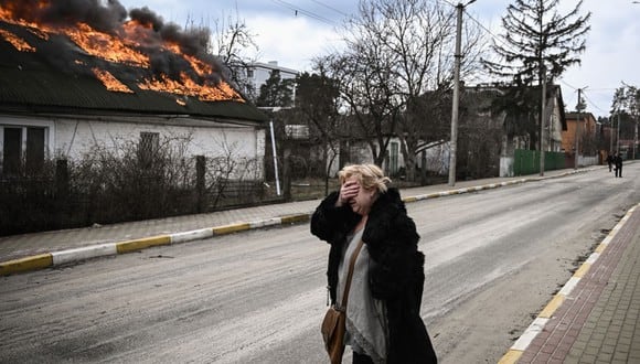 Una mujer reacciona frente a una casa en llamas después de ser bombardeada en la ciudad de Irpin, en las afueras de Kiev, el 4 de marzo de 2022. - Más de 1,2 millones de personas han huido de Ucrania a los países vecinos desde que Rusia lanzó su invasión a gran escala. el 24 de febrero, las cifras de las Naciones Unidas mostraron el 4 de marzo de 2022. (Foto de Aris Messinis / AFP)