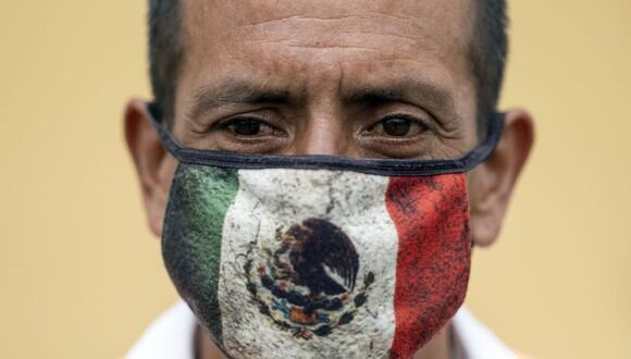 En esta foto de archivo tomada el 2 de agosto de 2020, Javier, un trabajador de la calle, posa para un retrato con una máscara facial que representa una bandera mexicana en Playas de Tijuana, estado de Baja California, México. (Guillermo Arias/AFP).