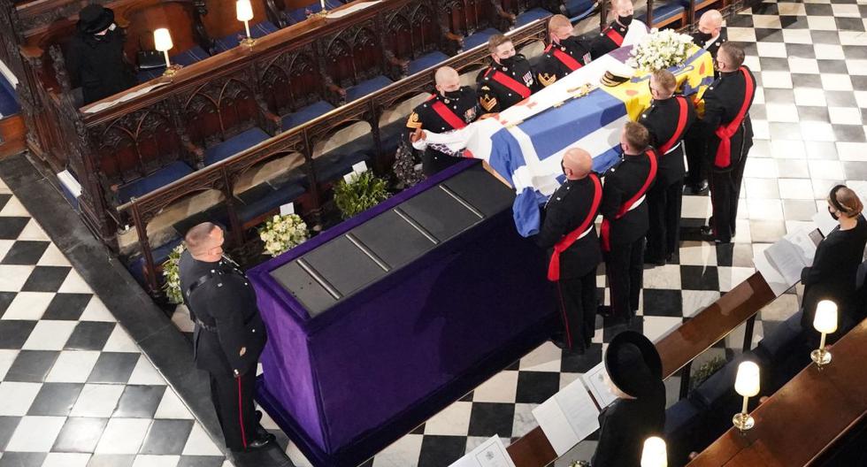 La reina Isabel II (izq.) observa cómo llevan el ataúd del príncipe Felipe de Gran Bretaña, duque de Edimburgo, durante su funeral dentro de la Capilla de San Jorge en el Castillo de Windsor en Windsor, al oeste de Londres, el 17 de abril de 2021. (Dominic Lipinski / POOL / AFP).