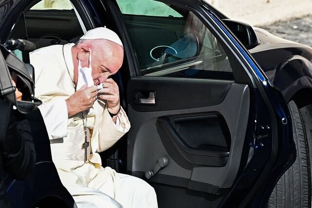 Fotografía del papa Francisco retirándose la mascarilla antes de bajar del automóvil que lo trasladó hasta el patio de San Dámaso en el Vaticano. (AFP / Vincenzo PINTO).