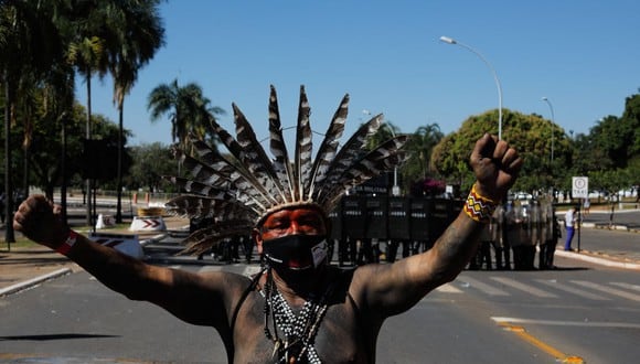 Indígenas protestan frente a una línea de policías antidisturbios cerca del  Congreso de Brasil. (Foto de Sergio Lima / AFP).