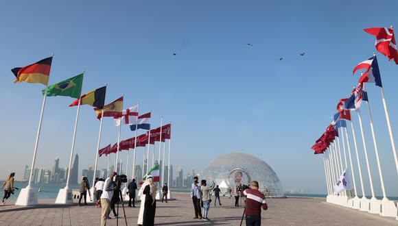 Las banderas de las naciones clasificatorias se izan a lo largo de Doha Corniche, frente al reloj de cuenta regresiva el 3 de febrero de 2022, mientras Qatar se prepara para albergar la Copa Mundial de la FIFA 2022. (Foto de KARIM JAAFAR / AFP)