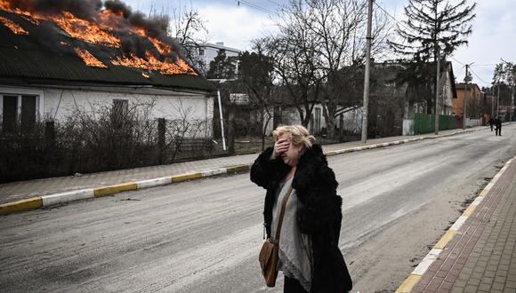 Una mujer reacciona frente a una casa en llamas después de ser bombardeada en la ciudad de Irpin, en las afueras de Kiev, el 4 de marzo de 2022. (Foto: Aris Messinis / AFP)