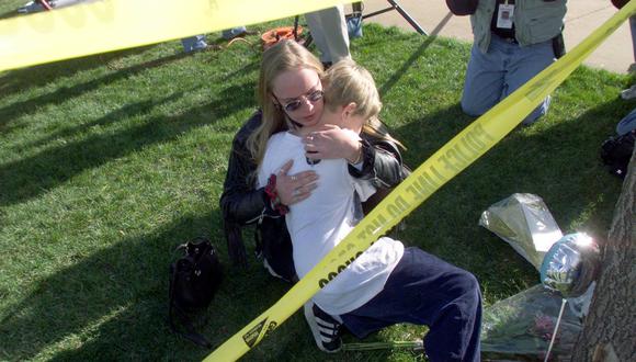 Una madre abraza a su hijo mientras presentan sus respetos el 21 de abril de 1999 a quienes murieron en el tiroteo de Columbine High School en Littleton, Colorado, el 20 de abril de 1999. (Foto: HECTOR MATA / AFP)