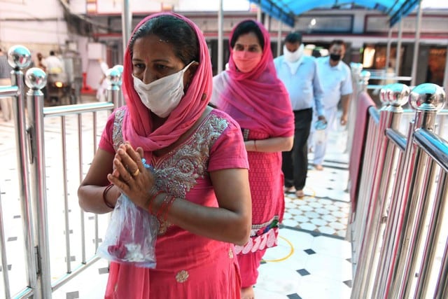 Devotos hindúes se alinean para realizar rituales en Shivala Bagh Bhayian Mandir, ya que los lugares de culto religioso, hoteles, restaurantes y centros comerciales pueden operar nuevamente después de más de dos meses de bloqueo impuesto como medida preventiva contra el coronavirus. (AFP / NARINDER NANU)