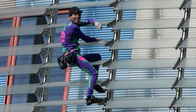 El escalador Alain Robert, conocido popularmente como el “Spiderman”, trepó sin cuerdas ni autorización un rascacielos en Barcelona para conscienciar de la necesidad de controlar el pánico por el coronavirus. (AFP)