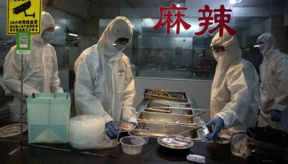 Un grupo de cocineros usan trajes de materiales peligrosos en Wenzhou, China. (AFP)