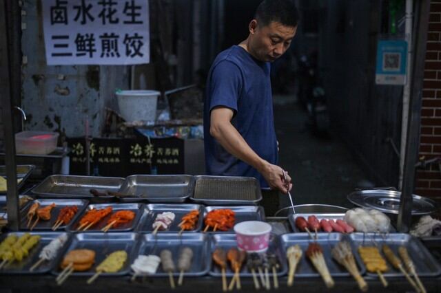Ciudadano sin mascarilla por el coronavirus es captado vendiendo comida en la ciudad de Wuhan (China). Foto del 4 de agosto de 2020. (AFP / Hector RETAMAL).