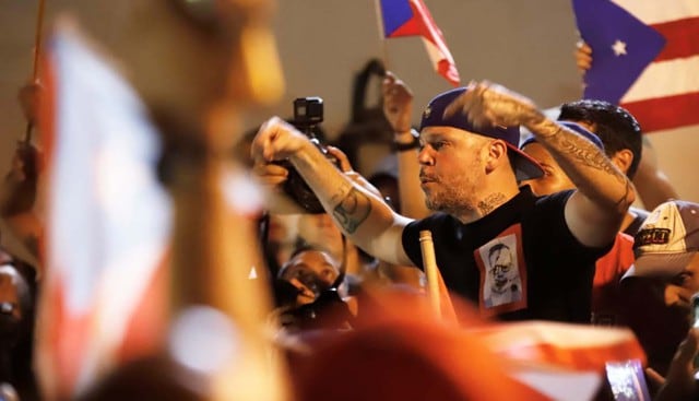 El cantante puertorriquño Residente (René Pérez, ex Calle 13) se une a cientos de personas que continúan en la calle durante una protesta, en San Juan (Puerto Rico) para exigir la renuncia de Ricardo Rosselló. (Foto: EFE)