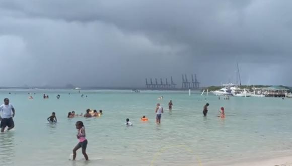 Los vacacionistas siguen en las aguas de una playa en Santa Domingo y no temen la llegada del huracán. (Captura: Listin Diario)