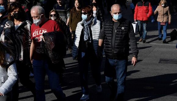 Personas, algunas con mascarillas, caminan por una calle mientras disfrutan de un día en Barcelona. (Foto: Pau BARRENA / AFP)