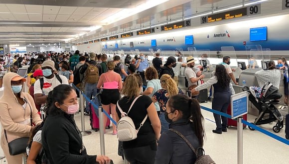 Los viajeros hacen fila en los mostradores de facturación de salida de American Airline en el Aeropuerto Internacional de Miami (MIA). (Foto: Daniel SLIM / AFP)