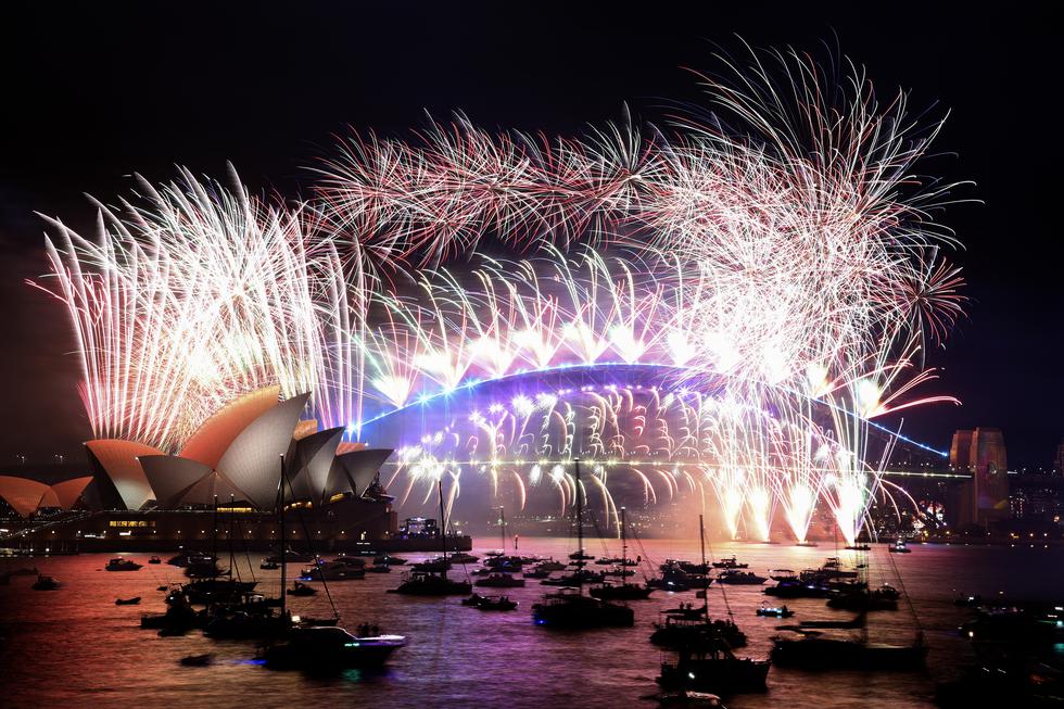 Fuegos artificiales de Nochevieja iluminan el cielo sobre el icónico Harbour Bridge y la Ópera  de Sydney durante el 1 de enero de 2022. (Foto de DAVID GREY / AFP)
