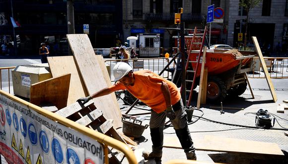 Un trabajador de la construcción mueve materiales en Barcelona el 19 de julio de 2022. - España, que ya vive su mayo más caluroso desde principios de este siglo, seguía el 19 de julio bajo las garras de una ola de calor excepcional. (Foto de Pau BARRENA / AFP)