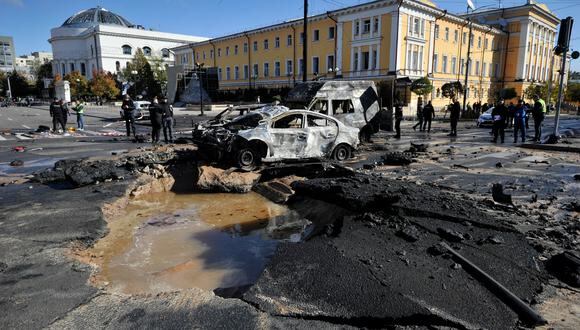 Expertos policiales examinan autos destruidos en el centro de la capital ucraniana de Kiev después de varios ataques rusos el 10 de octubre de 2022. (Foto: SERGEI CHUZAVKOV / AFP)