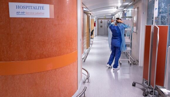 Foto referencial de una doctora caminando por el pasillo de un hospital. (Foto: Thomas SAMSON / AFP)