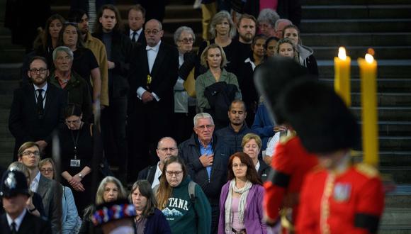 Los miembros del público presentan sus respetos al pasar junto al ataúd de la reina Isabel II mientras se encuentra en estado dentro de Westminster Hall. (Foto: Leon NEAL / POOL / AFP)