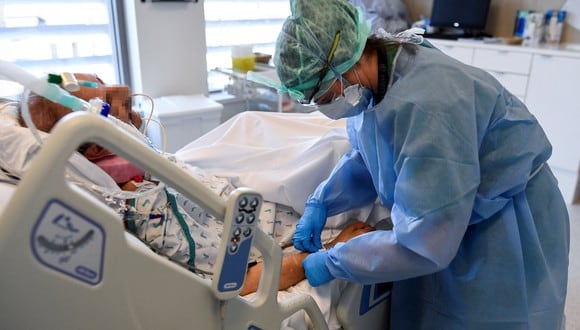 Un miembro del personal médico atiende a un paciente infectado por Covid-19 en la Unidad de Cuidados Intensivos del Hospital Etterbeek-Ixelles el 6 de abril de 2021, en Bruselas. (Foto: JOHN THYS / AFP)