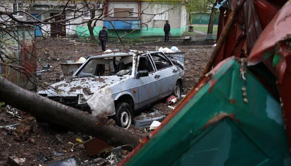 Los residentes locales miran un automóvil destruido junto a un edificio de varios pisos en Lysychansk, en la región de Luhansk. (Foto de Anatolii Stepanov / AFP)