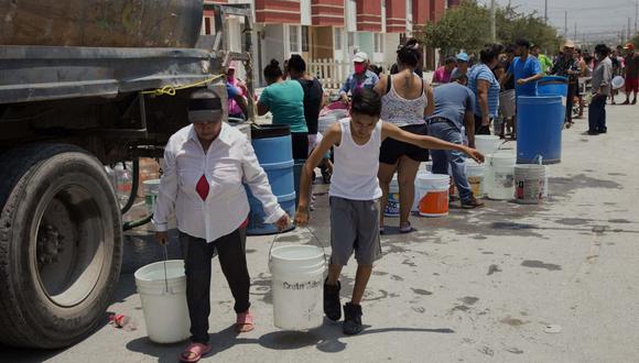 Residentes hacen cola para recoger agua limpia de un camión cisterna en el municipio de García, al noroeste del área metropolitana de Monterrey, estado de Nuevo León, México, el 8 de junio de 2022. (Foto de Julio Cesar AGUILAR / AFP)