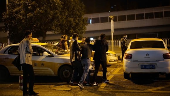 Un hombre es ayudado por amigos a subirse a un taxi frente a una discoteca. (Aly Song / Reuters).