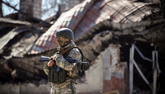 Un soldado ruso se para frente a un edificio de apartamentos el 11 de abril de 2022 en Volnovakha, en la región de Donetsk. (Foto de Alexander NEMENOV / AFP)