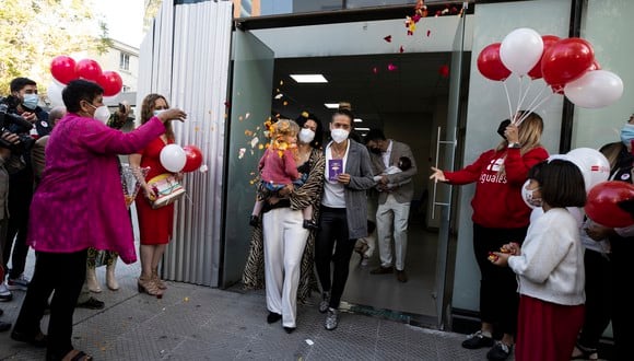 Paula Heuser (i) y Consuelo Morales (d), junto su hija, salen de una oficina del registro civil tras convertirse en una de las primeras parejas del mismo sexo en contraer matrimonio en Chile hoy, en Santiago (Chile). (Foto: EFE/ Alberto Valdés)