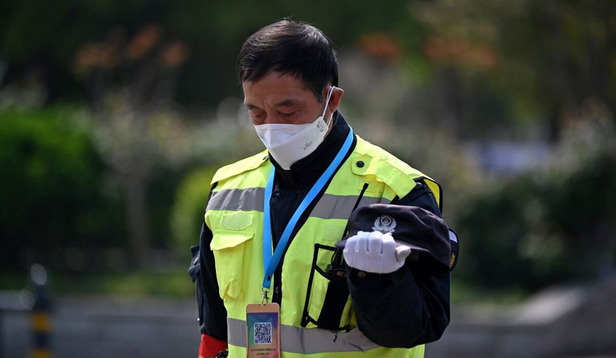 Oficiales de policía y funcionarios se detienen y presentan sus respetos durante tres minutos de silencio para llorar a los que murieron en la lucha contra la pandemia de coronavirus a lo largo de una calle en Wuhan, en la provincia central de Hubei. (Foto: AFP/Héctor Retamal)