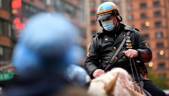 Un oficial de la policía de Nueva York con una máscara se sienta en su caballo frente a la entrada de la sala de emergencias mientras las personas aplauden para mostrar su gratitud al personal médico y los trabajadores esenciales fuera del hospital Langone Health, en la ciudad de Nueva York, en medio de la nueva pandemia de coronavirus. (Foto: AFP/Angela Weiss)