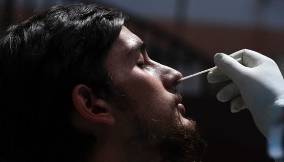 Un trabajador de la salud toma una muestra de un hisopo nasal para realizar la prueba del Covid-19 en un centro de pruebas en Srinagar. (Fpoto: TAUSEEF MUSTAFA / AFP)