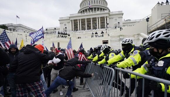 Los partidarios de Donald Trump intentan atravesar una barrera policial, el miércoles 6 de enero de 2021 en el Capitolio de Washington. (Foto AP / Julio Cortez).