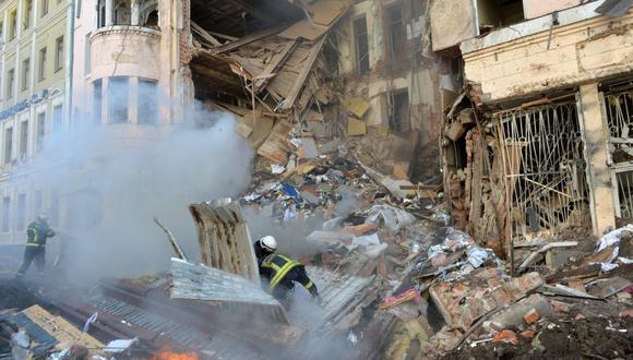 Los bomberos trabajan para limpiar los escombros y extinguir un incendio en un edificio gravemente dañado después de que un cohete ruso explotara en las afueras de la segunda ciudad de Ucrania, Kharkiv, el 14 de marzo de 2022, en medio de la actual invasión rusa de Ucrania. (Foto de Serguéi BOBOK / AFP)