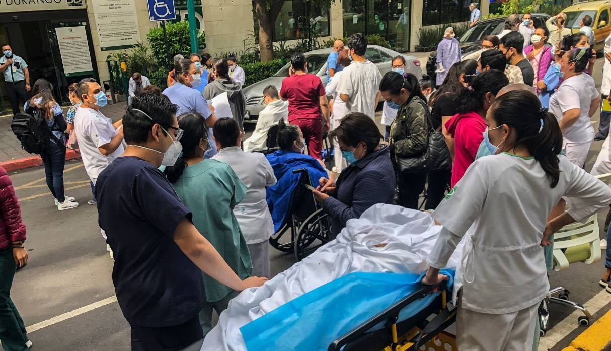 Los trabajadores de la salud y los pacientes permanecen fuera de la clínica de Durango en la Ciudad de México tras terremoto de magnitud 7,5. (AFP / Pedro PARDO).