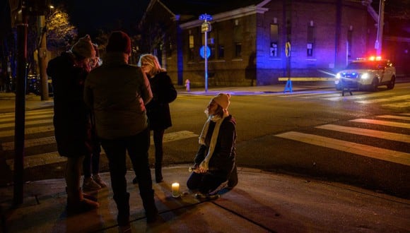 La gente realiza una vigilia con velas cerca de la escena de un incendio mortal el 5 de enero de 2022, en el popular distrito de museos de Fairmount en Filadelfia.  (Foto de Ed JONES / AFP)
