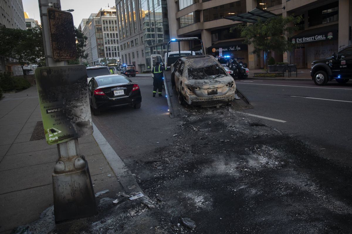 Un empleado de la ciudad retira un vehículo quemado de I Street NW en Washington, después de una noche de protestas por la muerte de George Floyd. Floyd murió después de ser retenido por agentes de policía de Minneapolis. (Foto AP / Carolyn Kaster)