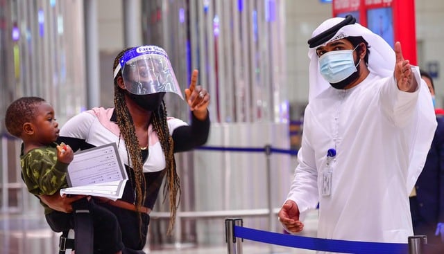 Un turista recibe instrucciones en el aeropuerto de Dubái en los Emiratos Árabes Unidos el 8 de julio de 2020, cuando el país reabrió sus puertas a los visitantes internacionales. (AFP / GIUSEPPE CACACE).