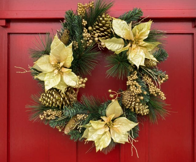 Coloca en tu puerta una corona navideña con piñas, ramas de pino y muérdago.